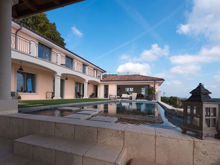 Pohled na bazén a dům s deskou Light Travertin v jemné béžové barvě