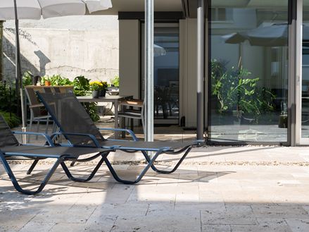 Stylový dvůr s travertinem a krásnou plochou na opalování