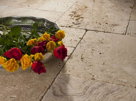 Podnos s růžemi na položených travertinových deskách v béžové a hnědé barvě