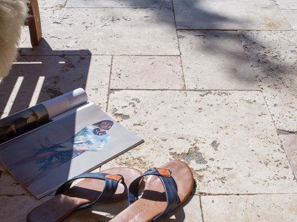 Časopis a boty na travertinové terase Rustic