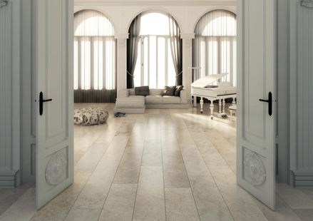 Stará budova s dvojitými dveřmi a světlou kamennou dlažbou jako podlahou