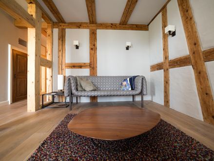 Pokoj s hrázděnými trámy a dřevěnou podlahou