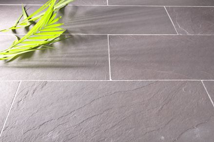 Dlaždice ve světle šedé barvě se zeleným dekorem