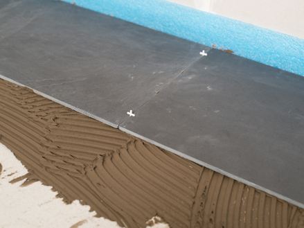 Spárovací kříže jako distanční prvky mezi dvěma břidlicovými dlaždicemi