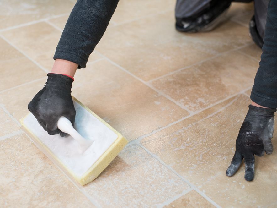 Obkladač čistí travertinovou podlahu po pokládce