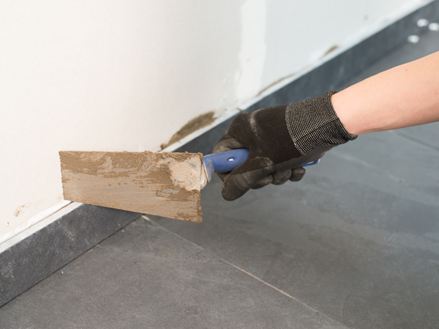 Stírání spárovací hmoty stěrkou