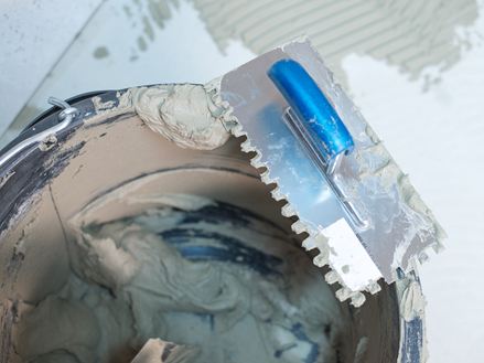 Kbelík lepidla na přírodní kámen a zubová stěrka