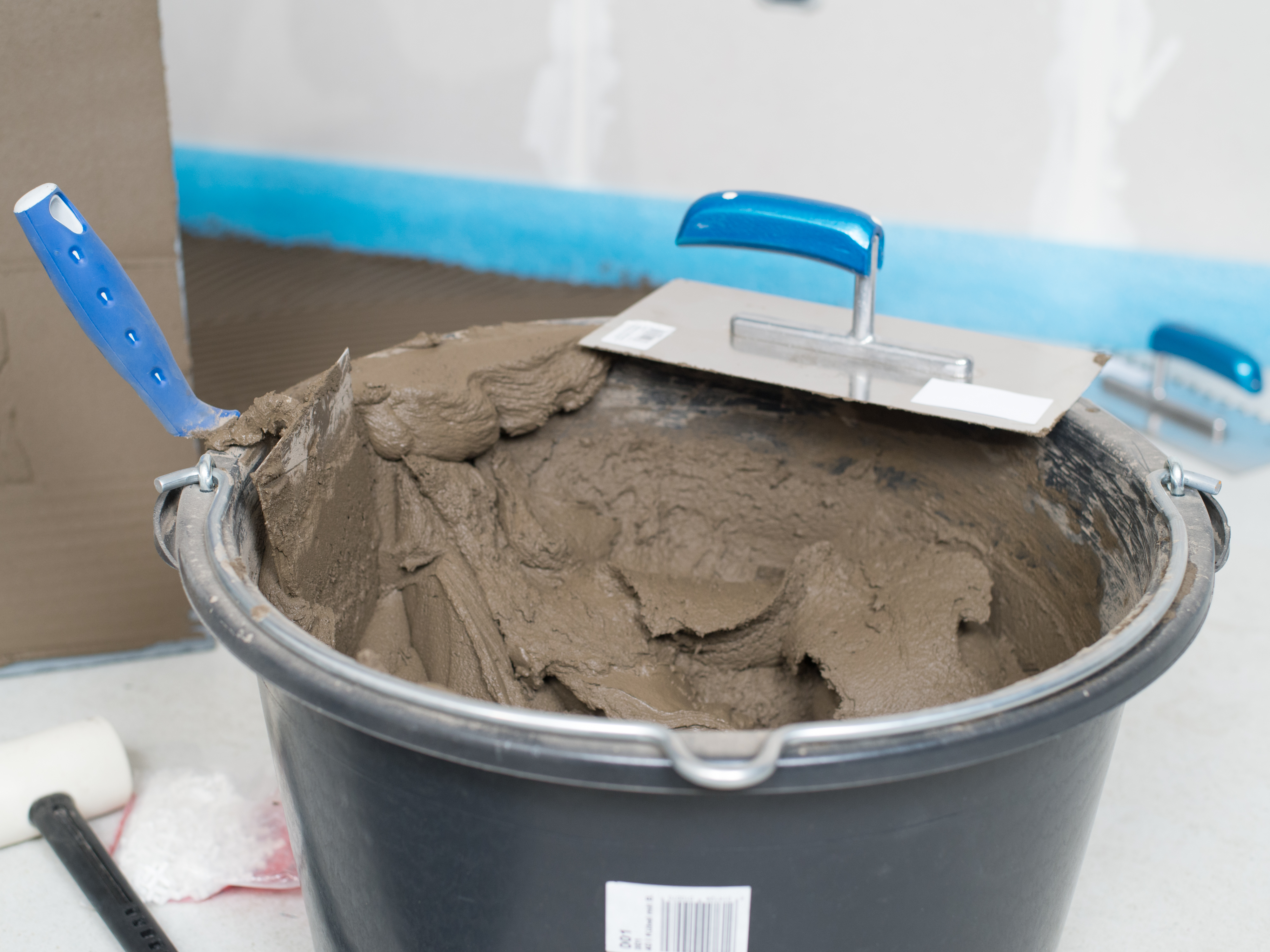 Kbelík lepidla na přírodní kámen a zubová stěrka