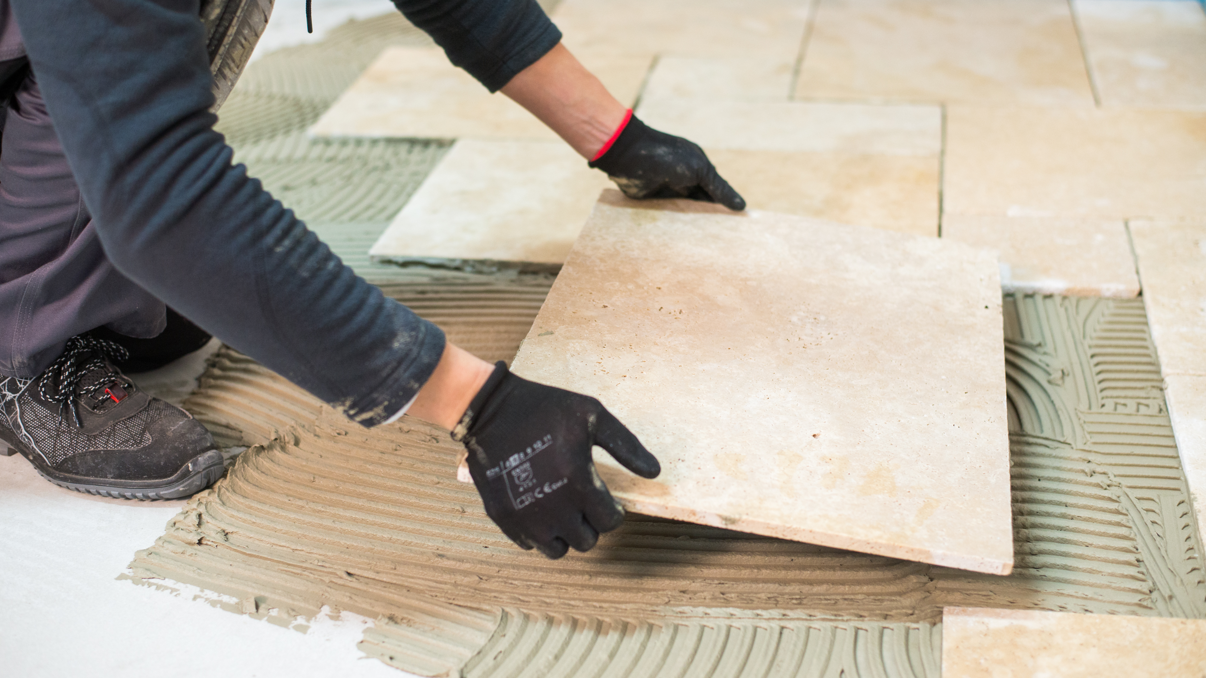 Obkladač pokládá travertinové dlaždice